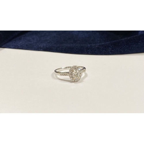 14 - A STUNNING 14CT WHITE GOLD DIAMOND CLUSTER RING, with central oval brilliant cut diamond, weight: .5... 