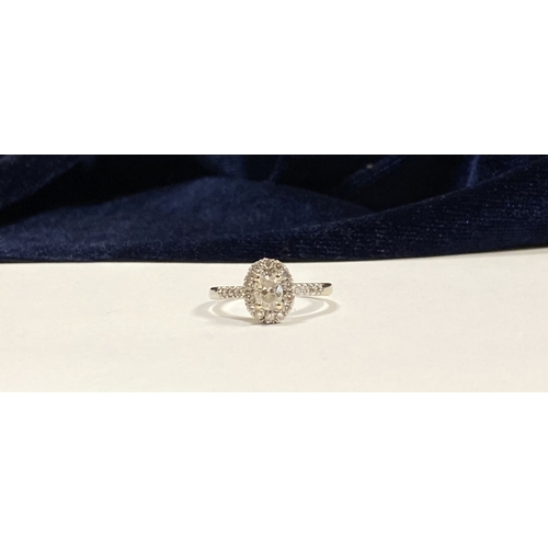 14 - A STUNNING 14CT WHITE GOLD DIAMOND CLUSTER RING, with central oval brilliant cut diamond, weight: .5... 