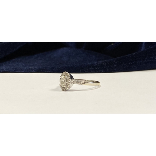 14 - A STUNNING 14CT WHITE GOLD DIAMOND CLUSTER RING, with central oval brilliant cut diamond, weight: .5... 