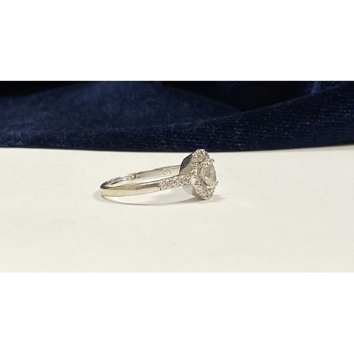 14 - A STUNNING 14CT WHITE GOLD DIAMOND CLUSTER RING, with central oval brilliant cut diamond, weight: .5... 