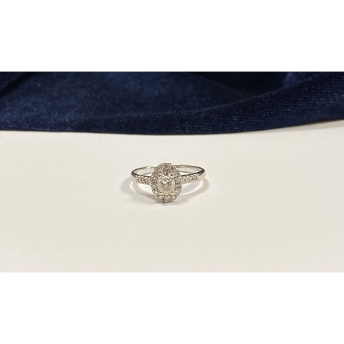 14 - A STUNNING 14CT WHITE GOLD DIAMOND CLUSTER RING, with central oval brilliant cut diamond, weight: .5... 