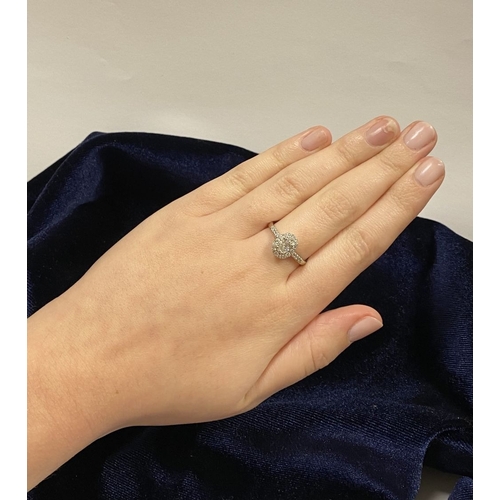 14 - A STUNNING 14CT WHITE GOLD DIAMOND CLUSTER RING, with central oval brilliant cut diamond, weight: .5... 