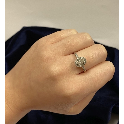 14 - A STUNNING 14CT WHITE GOLD DIAMOND CLUSTER RING, with central oval brilliant cut diamond, weight: .5... 