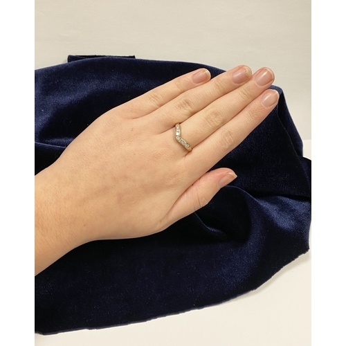 50 - A DAINTY 9CT YELLOW GOLD CUBIC ZIRCONIA WISHBONE RING, with seven round cut cubic zirconia channel s... 