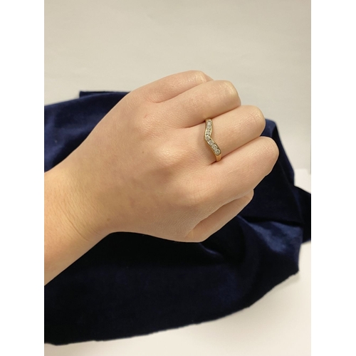 50 - A DAINTY 9CT YELLOW GOLD CUBIC ZIRCONIA WISHBONE RING, with seven round cut cubic zirconia channel s... 