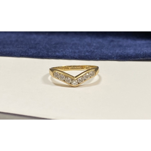 50 - A DAINTY 9CT YELLOW GOLD CUBIC ZIRCONIA WISHBONE RING, with seven round cut cubic zirconia channel s... 