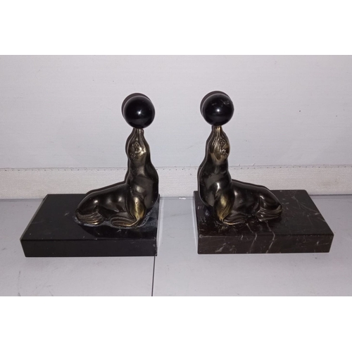 61 - A PAIR OF ORIGINAL ART DECO PERIOD BOOKENDS, in the form of seal balancing ball, on marble bases. Di... 
