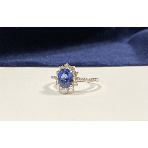 7 - A STRIKING 18CT WHITE GOLD SAPPHIRE & DIAMOND CLUSTER RING, with central vibrant oval cur sapphire i... 