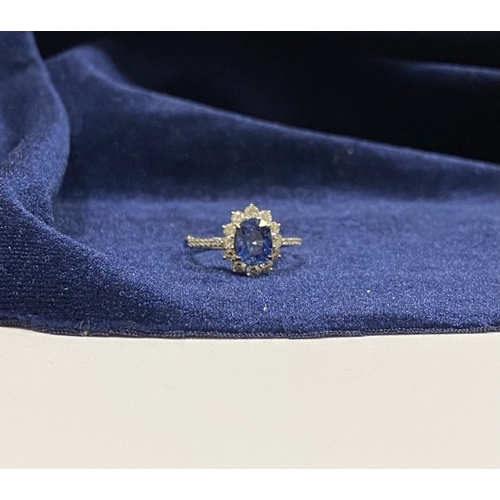 7 - A STRIKING 18CT WHITE GOLD SAPPHIRE & DIAMOND CLUSTER RING, with central vibrant oval cur sapphire i... 