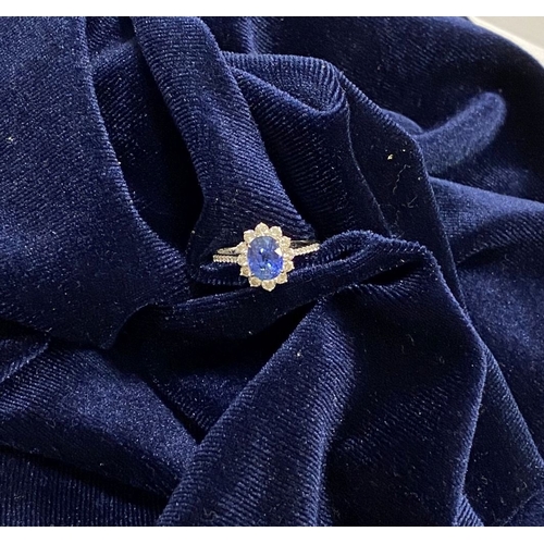 7 - A STRIKING 18CT WHITE GOLD SAPPHIRE & DIAMOND CLUSTER RING, with central vibrant oval cur sapphire i... 