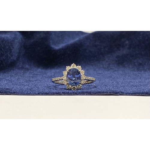 7 - A STRIKING 18CT WHITE GOLD SAPPHIRE & DIAMOND CLUSTER RING, with central vibrant oval cur sapphire i... 