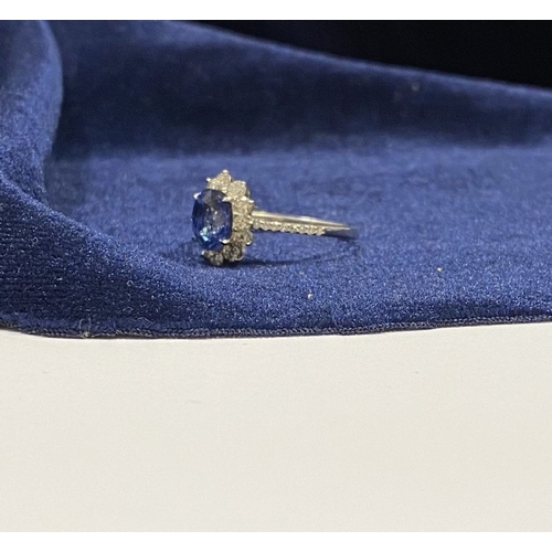 7 - A STRIKING 18CT WHITE GOLD SAPPHIRE & DIAMOND CLUSTER RING, with central vibrant oval cur sapphire i... 