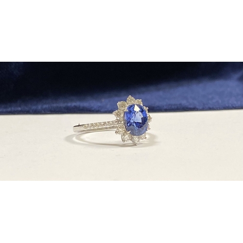 7 - A STRIKING 18CT WHITE GOLD SAPPHIRE & DIAMOND CLUSTER RING, with central vibrant oval cur sapphire i... 