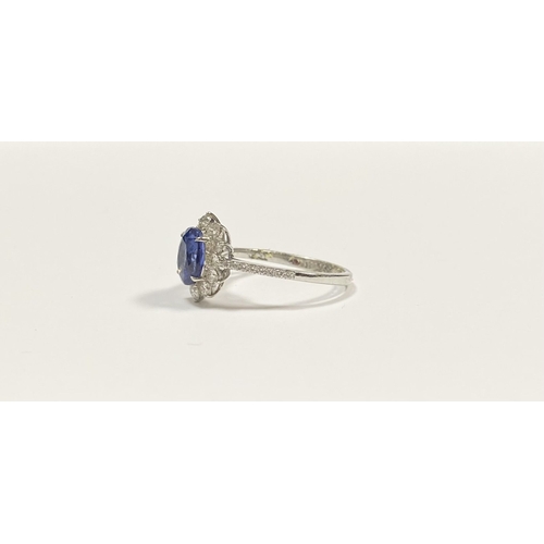 7 - A STRIKING 18CT WHITE GOLD SAPPHIRE & DIAMOND CLUSTER RING, with central vibrant oval cur sapphire i... 