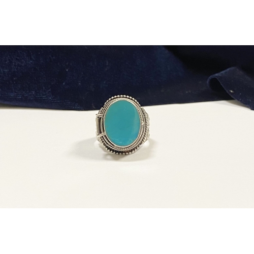 72 - A STERLING SILVER & TURQUOISE ‘LOCKET/POISON’ RING, featuring oval cut turquoise bezel set in raised... 