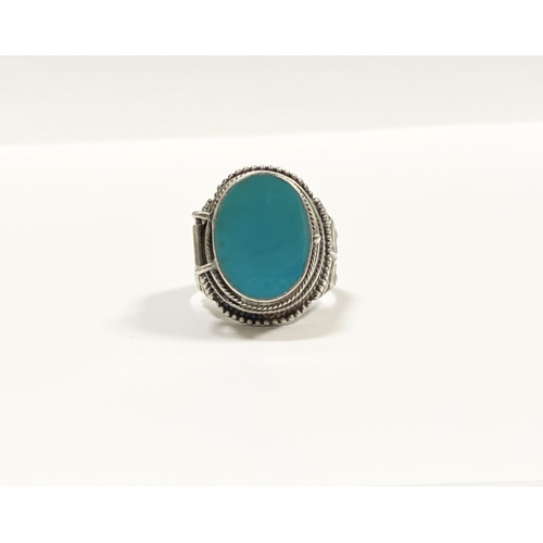 72 - A STERLING SILVER & TURQUOISE ‘LOCKET/POISON’ RING, featuring oval cut turquoise bezel set in raised... 