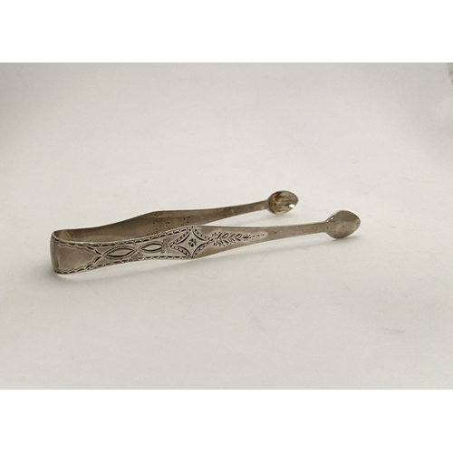 73 - A FINE GEORGE III SILVER SUGAR TONGS, with intricate bright cut engraving featuring diamond and blan... 