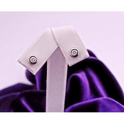 74 - A PAIR OF DIAMOND STUD EARRINGS each in a roll-over cylindrical column setting, with ALPA secure bac... 