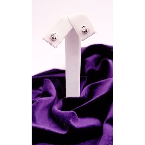 74 - A PAIR OF DIAMOND STUD EARRINGS each in a roll-over cylindrical column setting, with ALPA secure bac... 