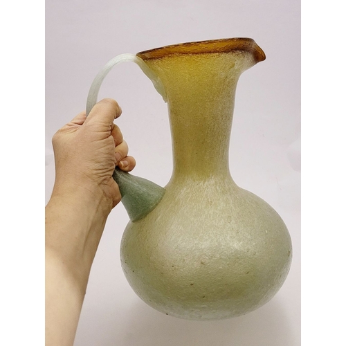 96 - A VINTAGE EARLY 20TH CENTURY ‘STRETCH-GLASS’ PITCHER, the beautifully formed glass pitcher has a cur... 