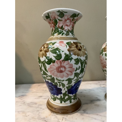 105 - A DECORATIVE PAIR OF FLORAL PAINTED VASES, baluster form with flared rim, painted with floral design... 