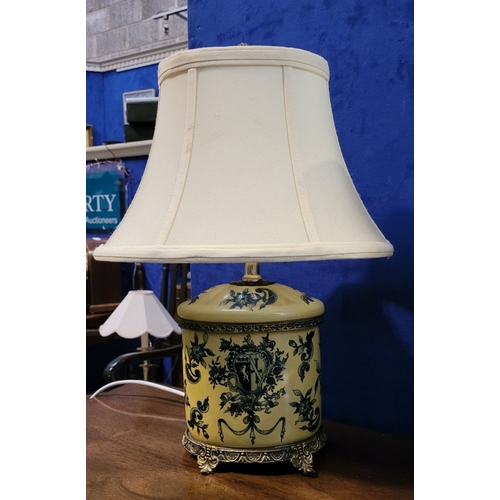 107 - A PAIR OF YELLOW & BLUE CERAMIC TABLE LAMPS, with shades, resting on metal feet. Bases are in good c... 