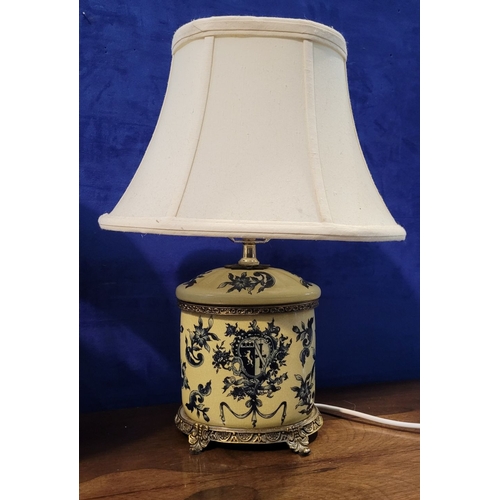 107 - A PAIR OF YELLOW & BLUE CERAMIC TABLE LAMPS, with shades, resting on metal feet. Bases are in good c... 