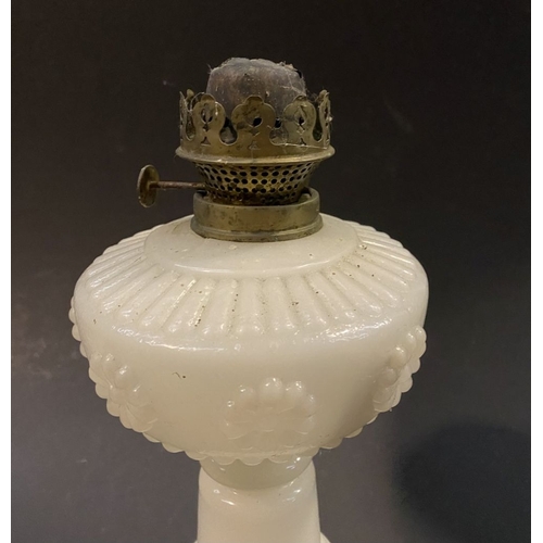 119 - AN ANTIQUE MILK GLASS OIL LAMP, the font with moulded flowers surrounding, on Column base on circula... 