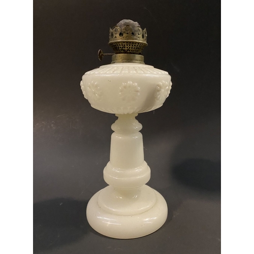 119 - AN ANTIQUE MILK GLASS OIL LAMP, the font with moulded flowers surrounding, on Column base on circula... 