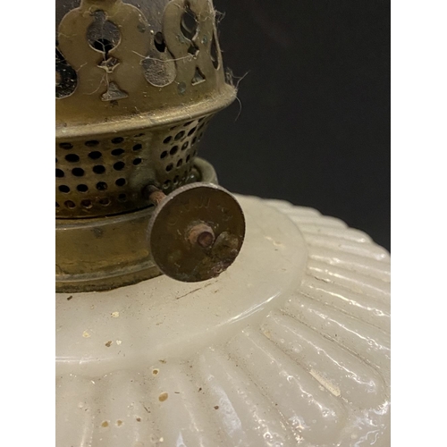 119 - AN ANTIQUE MILK GLASS OIL LAMP, the font with moulded flowers surrounding, on Column base on circula... 