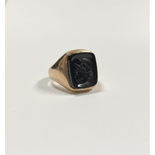 128 - A CARVED BLACK ONYX INTAGLIO SIGNET RING, with central rectangular carved black onyx with rounded co... 