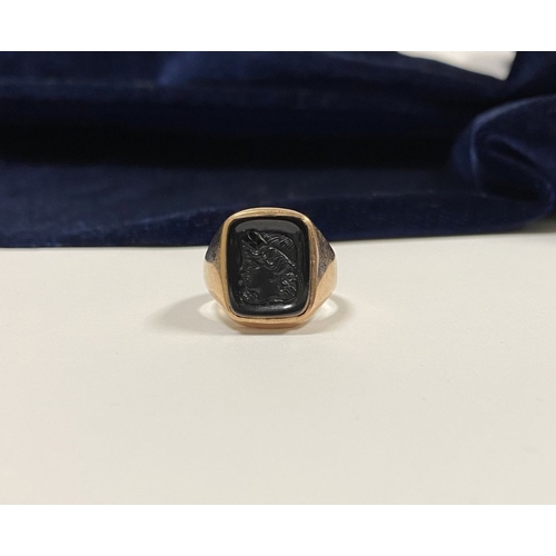 128 - A CARVED BLACK ONYX INTAGLIO SIGNET RING, with central rectangular carved black onyx with rounded co... 