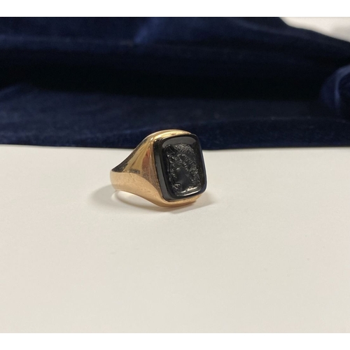 128 - A CARVED BLACK ONYX INTAGLIO SIGNET RING, with central rectangular carved black onyx with rounded co... 