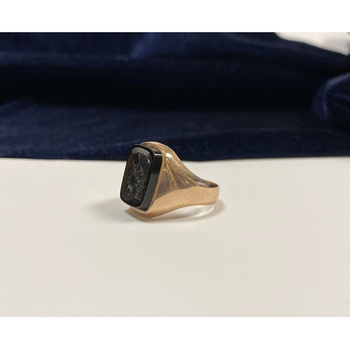 128 - A CARVED BLACK ONYX INTAGLIO SIGNET RING, with central rectangular carved black onyx with rounded co... 