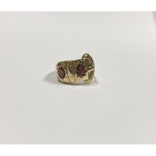 129 - A 14CT YELLOW GOLD GARNET BUCKLE RING, with featuring two illusion set oval cut garnets within highl... 