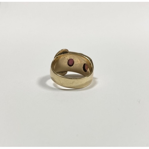 129 - A 14CT YELLOW GOLD GARNET BUCKLE RING, with featuring two illusion set oval cut garnets within highl... 