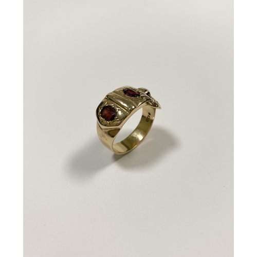 129 - A 14CT YELLOW GOLD GARNET BUCKLE RING, with featuring two illusion set oval cut garnets within highl... 