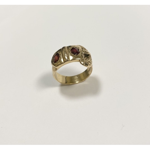 129 - A 14CT YELLOW GOLD GARNET BUCKLE RING, with featuring two illusion set oval cut garnets within highl... 