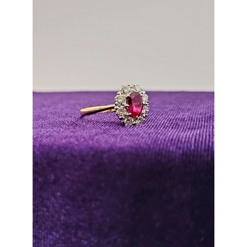 13 - A GORGEOUS 18CT YELLOW GOLD & PLATINUM DIAMOND & RUBY CLUSTER RING, an oval cut ruby is set to the c... 