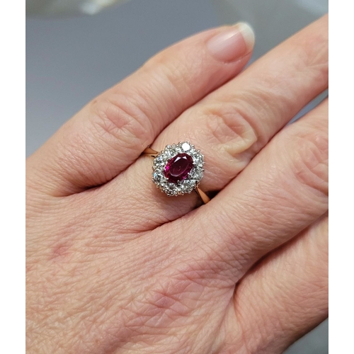 13 - A GORGEOUS 18CT YELLOW GOLD & PLATINUM DIAMOND & RUBY CLUSTER RING, an oval cut ruby is set to the c... 