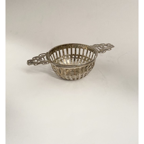 131 - AN EDWARD VII PIERCED SILVER TEA STRAINER ALONG WITH WINE COASTER, (i) the tea strainer of circular ... 