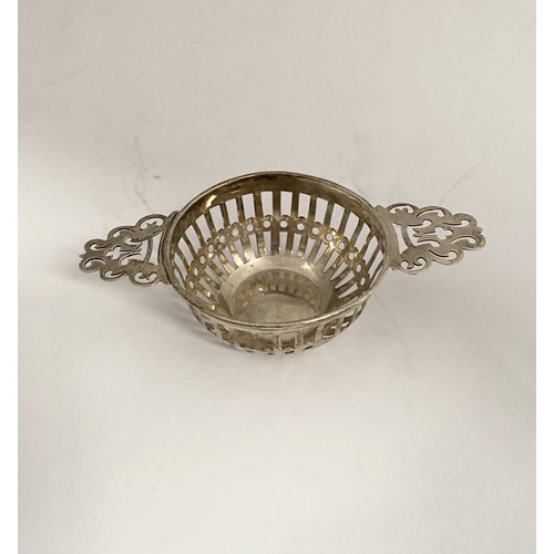 131 - AN EDWARD VII PIERCED SILVER TEA STRAINER ALONG WITH WINE COASTER, (i) the tea strainer of circular ... 