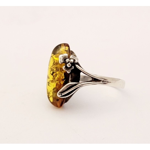 137 - A VINTAGE AMBER RING, with beautiful floral & foliage design to the split shank, unmarked but possib... 