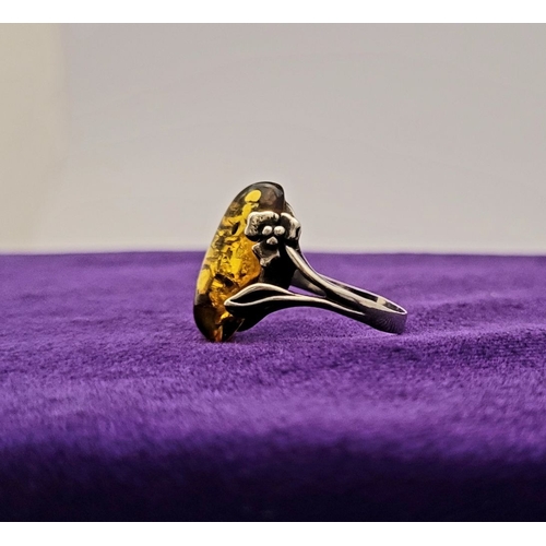 137 - A VINTAGE AMBER RING, with beautiful floral & foliage design to the split shank, unmarked but possib... 