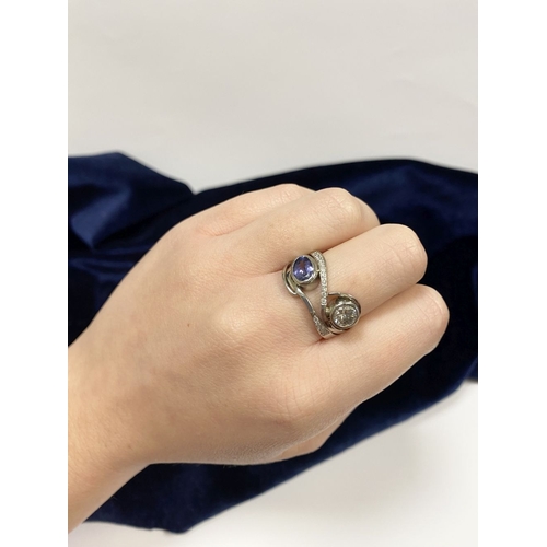 14 - A STUNNING HANDMADE PLATINUM DIAMOND AND TANZANITE RING, with beautiful round brilliant cut diamond ... 