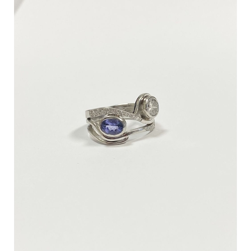 14 - A STUNNING HANDMADE PLATINUM DIAMOND AND TANZANITE RING, with beautiful round brilliant cut diamond ... 