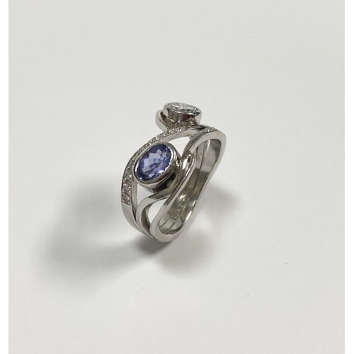 14 - A STUNNING HANDMADE PLATINUM DIAMOND AND TANZANITE RING, with beautiful round brilliant cut diamond ... 