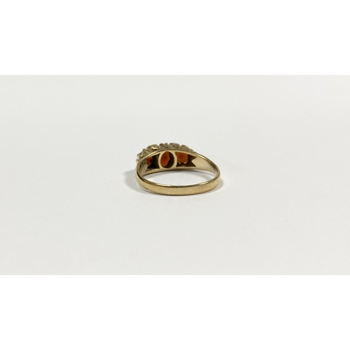 140 - A BEAUTIFUL 9CT YELLOW GOLD THREE STONE GARNET RING, with central oval gut garnet flanked by two rou... 