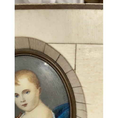 15 - A 19TH CENTURY BONE FRAMED OVAL MINIATURE PORTRAIT, depicting and infant, semi-reclined on blue cush... 