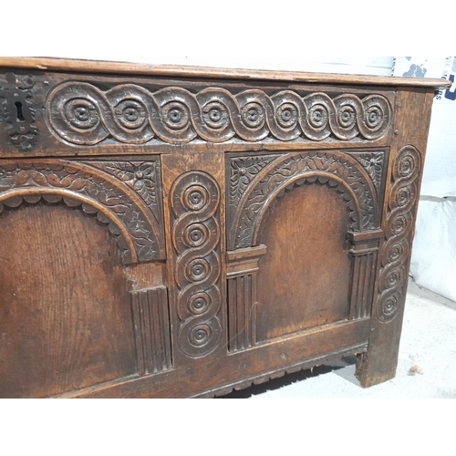 154 - AN LARGE ANTIQUE TRUNK, with nicely carved triple panel design to front, metal fittings, opening to ... 